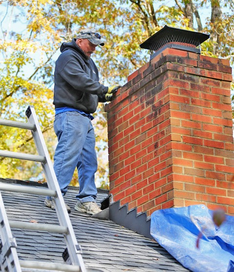 Roofer repairing a brick chimney on a GTA home
